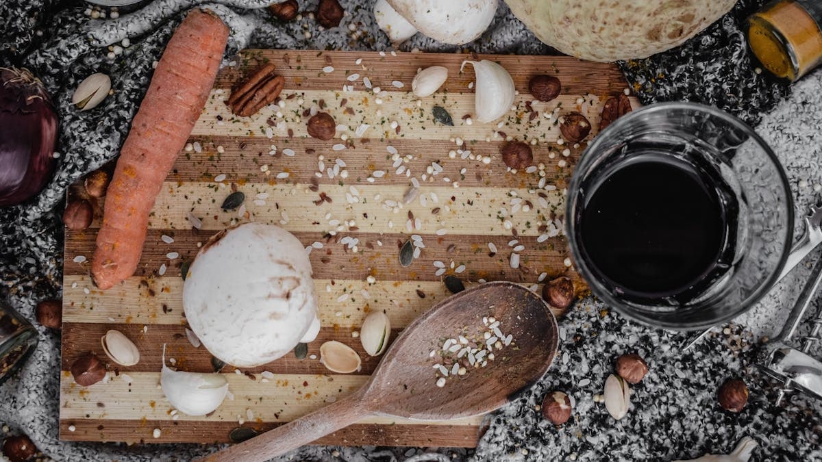 A rustic flat lay of assorted kitchen ingredients on a wooden board, perfect for culinary themes.